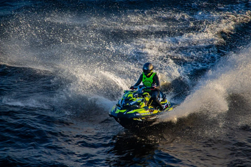 A jet ski rider carving through the water with a trail of spray